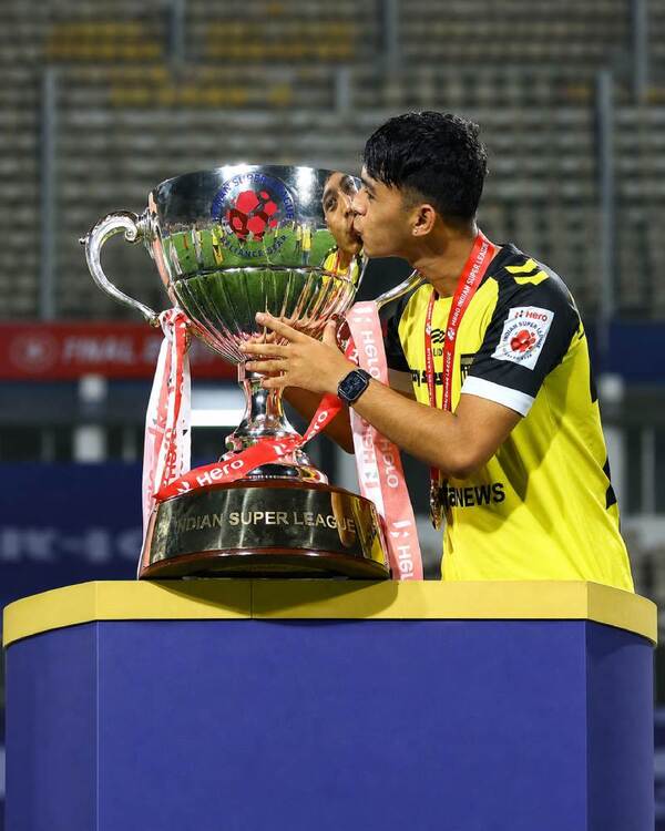 Rohit Danu celebrating with a football trophy